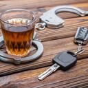 Concept drunkenness driving. Handcuffs, a glass of alcohol, car keys.