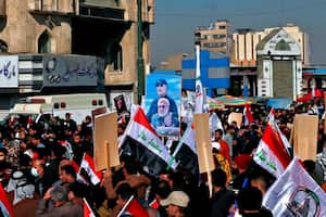 Supporters of the Popular Mobilization Forces hold a poster of Abu Mahdi al-Muhandis, deputy commander of the Popular Mobilization Forces, front, and General Qassem Soleimani, head of Iran's Quds force during a protest, in Tahrir Square, Iraq, Sunday, Jan. 3, 2021. Thousands of Iraqis converged on a landmark central square in Baghdad on Sunday to commemorate the anniversary of the killing of Soleimanil and al-Muhandis in a U.S. drone strike. (AP Photo/Khalid Moha