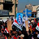 Supporters of the Popular Mobilization Forces hold a poster of Abu Mahdi al-Muhandis, deputy commander of the Popular Mobilization Forces, front, and General Qassem Soleimani, head of Iran's Quds force during a protest, in Tahrir Square, Iraq, Sunday, Jan. 3, 2021. Thousands of Iraqis converged on a landmark central square in Baghdad on Sunday to commemorate the anniversary of the killing of Soleimanil and al-Muhandis in a U.S. drone strike. (AP Photo/Khalid Moha
