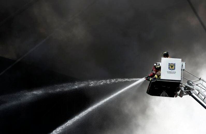 Un bombero rocía agua sobre las llamas Foto León Darío Peláez