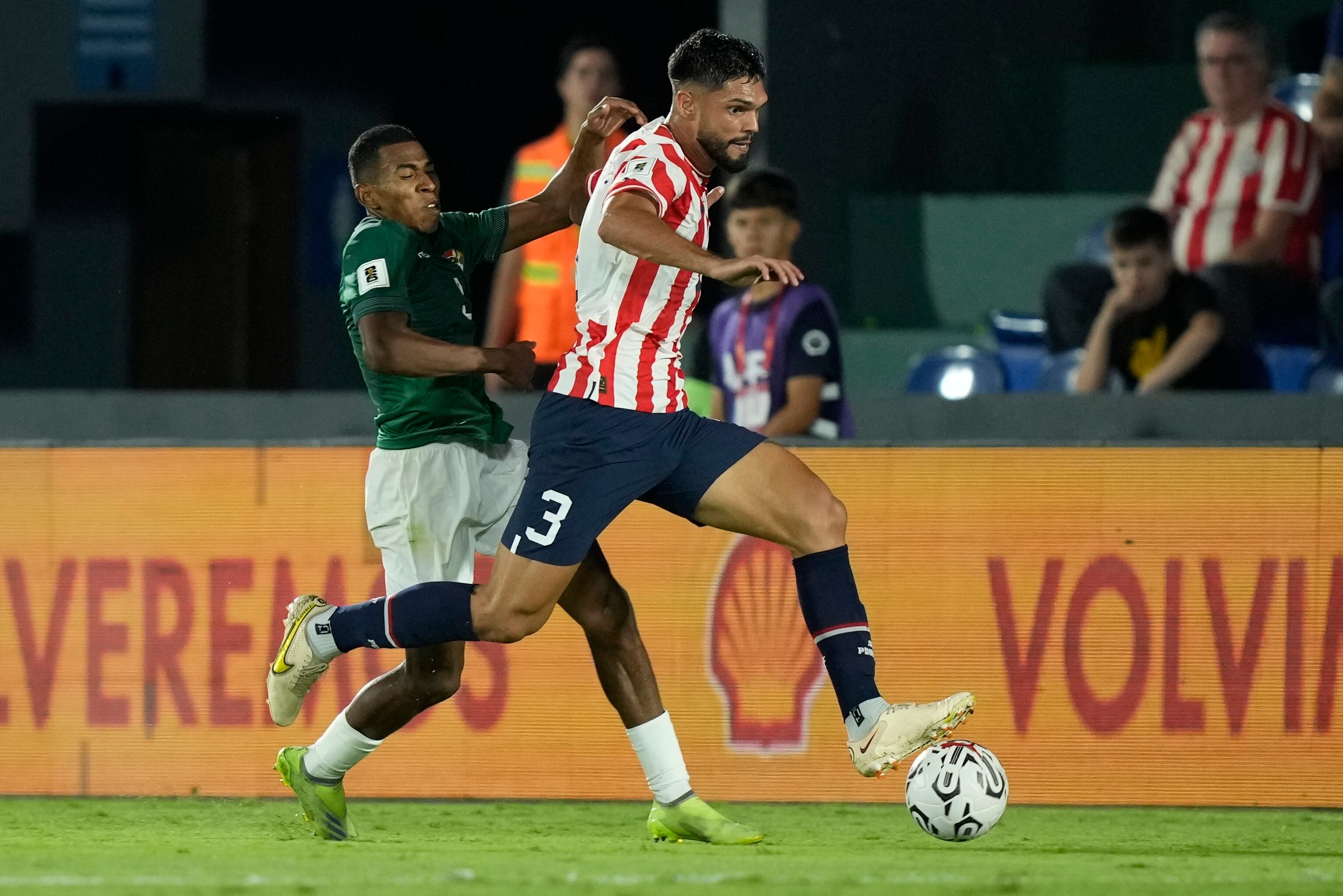 Diego Medina de Bolivia, izquierda, pelea por el balón con Omar Alderete de Paraguay durante un partido de fútbol de clasificación para la Copa Mundial de la FIFA 2026, en el Estadio Defensores del Chaco en Asunción, Paraguay, el martes 17 de octubre de 2023. (Foto AP/Jorge Saenz )