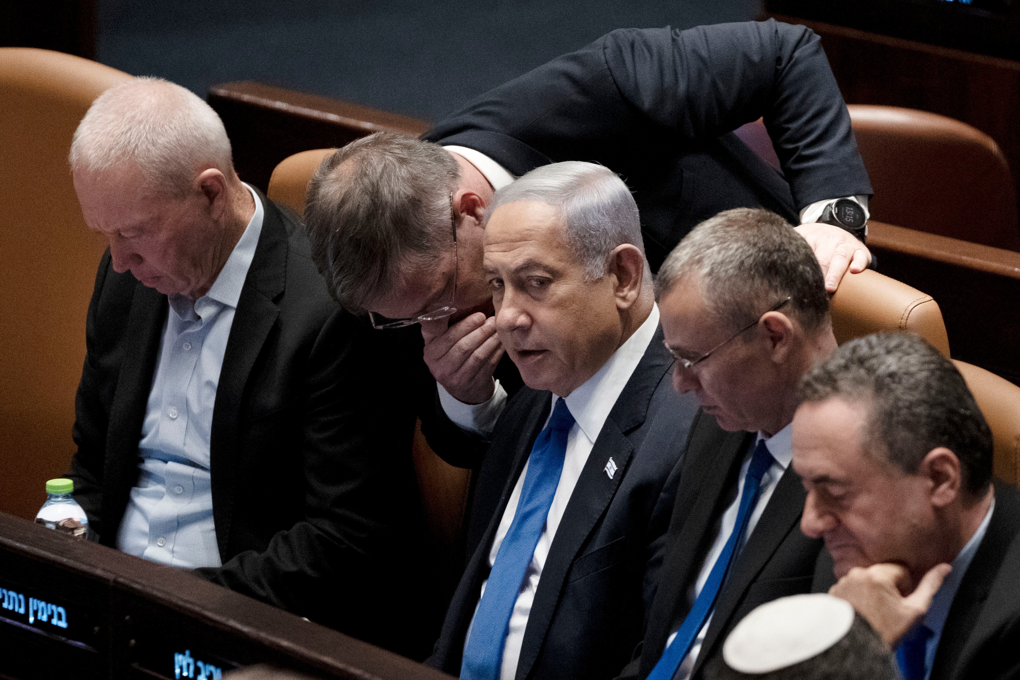 Los legisladores rodean al primer ministro de Israel, Benjamin Netanyahu, centro, en una sesión de la Knesset, el parlamento de Israel, en Jerusalén, el lunes 24 de julio de 2023.