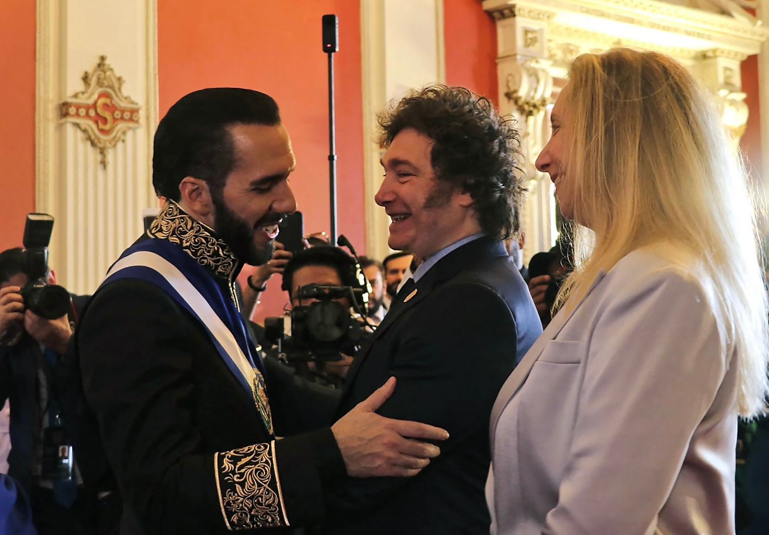 Esta imagen publicada por la Presidencia argentina muestra al presidente de El Salvador, Nayib Bukele (izq.), saludando al presidente de Argentina, Javier Milei (centro), y a su hermana y secretaria general de la presidencia, Karina Milei, durante su ceremonia de toma de posesión en el Palacio Nacional en el centro de San Salvador en junio.