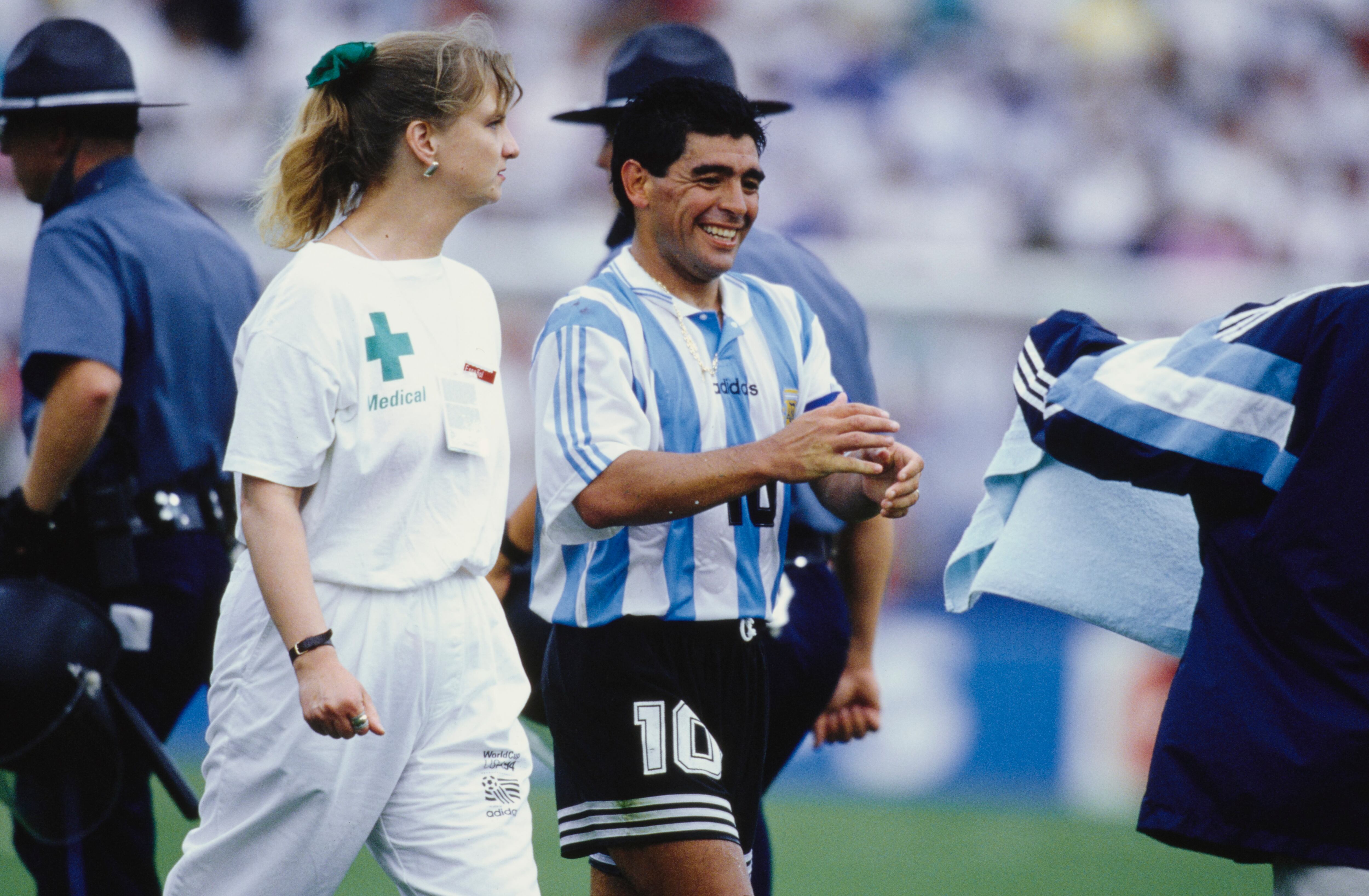 Argentine professional football player Diego Armando Maradona (1960 - 2020) leaves the pitch escorted by a nurse for a routine doping check during the 1994 FIFA World Cup Group D match Argentina vs Nigeria at Foxboro Stadium, Foxborough, US, 25th June 1994. (Photo by Michael Kunkel/Bongarts/Getty Images)