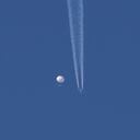 En esta foto proporcionada por Brian Branch, un gran globo se desplaza por encima de la zona de Kingstown, Carolina del Norte, mientras por debajo se observa un avión y la estela que deja a su paso