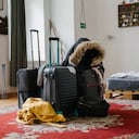 Some holiday goers luggage and belongings in the middle of the living room in a rental property.