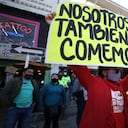 Un hombre sostiene un cartel durante una protesta para exigir el derecho a trabajar durante una cuarentena para evitar más contagios del nuevo coronavirus en Bogotá, Colombia, el viernes 29 de enero de 2021. (AP Foto/Fernando Vergara)