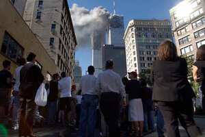 Los peatones en el Bajo Manhattan Mire el humo de humo del World Trade Center de Nueva York el martes 11 de septiembre de 2001. Foto de AP / Amy Sancetta.