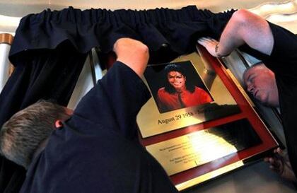 Diversas personas asisten a la instalación de una placa que conmemora el primer aniversario de la muerte de Michael Jackson en el Lyric Theatre de Londres, Reino Unido.