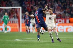 El delantero inglés del Bayern Munich #09 Harry Kane (R) y el defensor ecuatoriano #51 del Paris Saint-Germain Willian Pacho compiten por el balón.