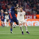 El delantero inglés del Bayern Munich #09 Harry Kane (R) y el defensor ecuatoriano #51 del Paris Saint-Germain Willian Pacho compiten por el balón.