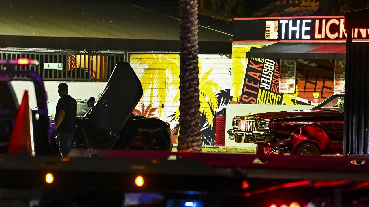 Se ven agujeros de bala y vidrios rotos en un automóvil que es remolcado desde el restaurante "The Licking".