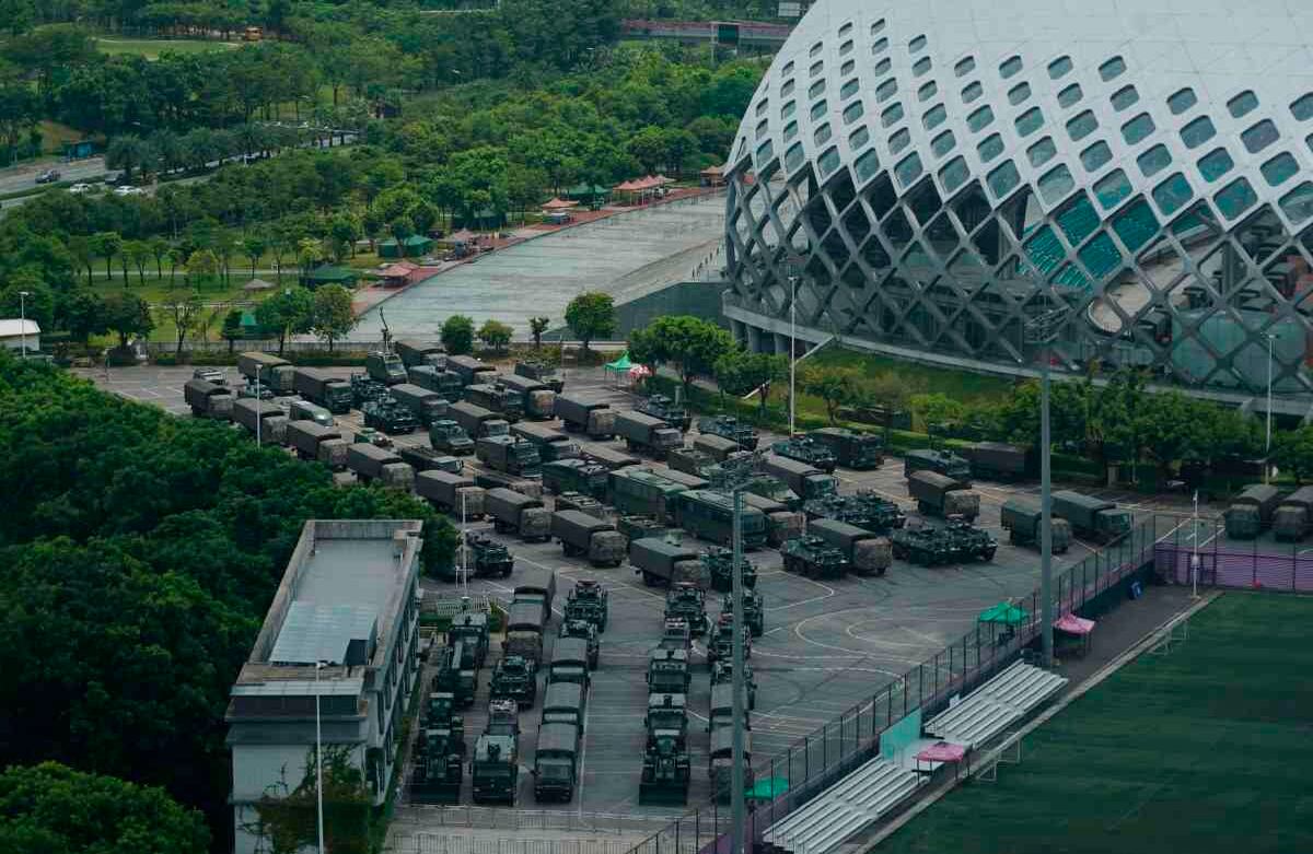 Vehículos blindados y camiones de tropa se estacionan en en el Shenzhen Bay Stadium, en Shenzhen, China, el viernes 16 de agosto de 2019. Los vehículos armados, pertenecientes a la Policía Popular Armada paramilitar de China, han sido estacionados en el complejo deportivo al otro lado de la frontera en Hong Kong, en un acto que algunos han interpretado como una amenaza a los manifestantes prodemocráticos. (Foto AP / Dake Kang)