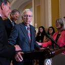 Senate Minority Leader Mitch McConnell, R-Ky., center, is helped by, from left, Sen. John Barrasso, R-Wyo., Sen. John Thune, R-S.D., and Sen. Joni Ernst, R-Iowa, after the 81-year-old GOP leader froze at the microphones as he arrived for a news conference, at the Capitol in Washington, Wednesday, July 26, 2023. McConnell went to his office for a few minutes and returned to speak with reporters. (AP Photo/J. Scott Applewhite)