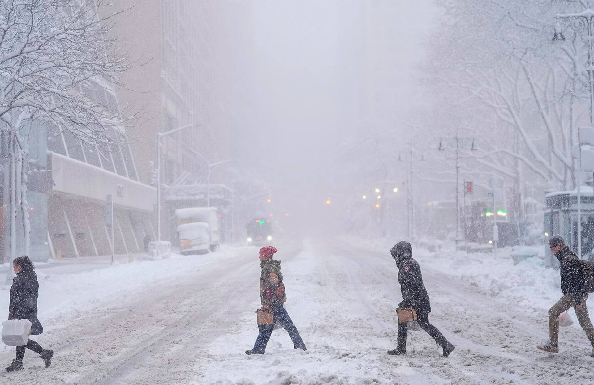 Peatones cruzan la calle 42, cerca de Bryant Park, en Nueva York, durante una tormenta de nieve el lunes 23 de febrero de 2026.