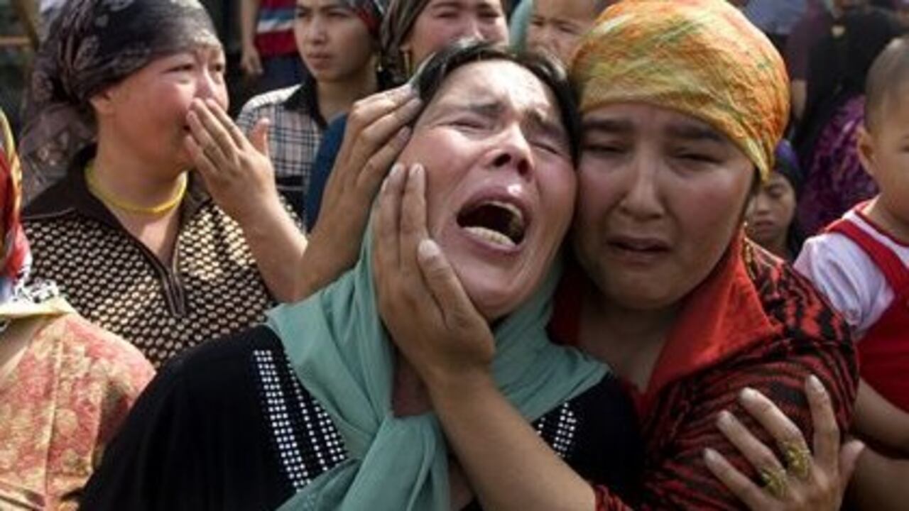 Mujeres de la etnia Uighur lloran después de que la policía chian se llevara a varios hombres de su comunidad.