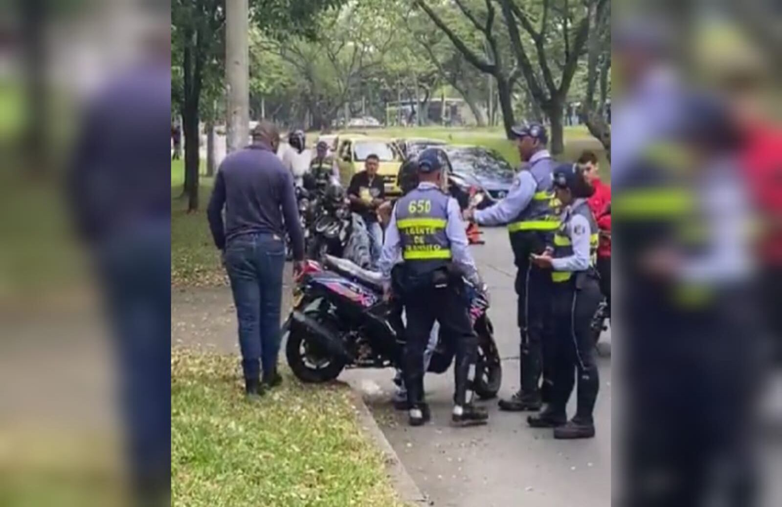 Motociclista en Cali se opone a tres agentes de tránsito tras recibir una multa por no tener licencia.