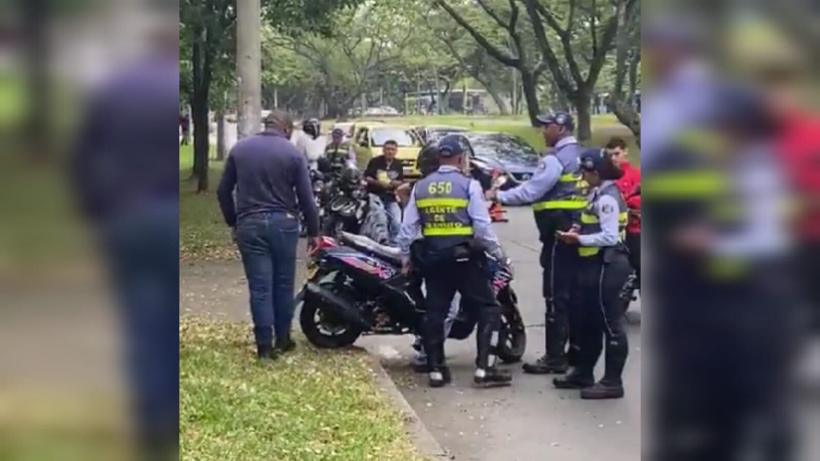 Motociclista en Cali se opone a tres agentes de tránsito tras recibir una multa por no tener licencia.