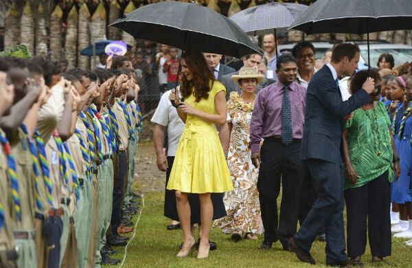 El príncipe Guillermo y su esposa Kate, caminan con paraguas sobre una fila de honor de los boy scouts.