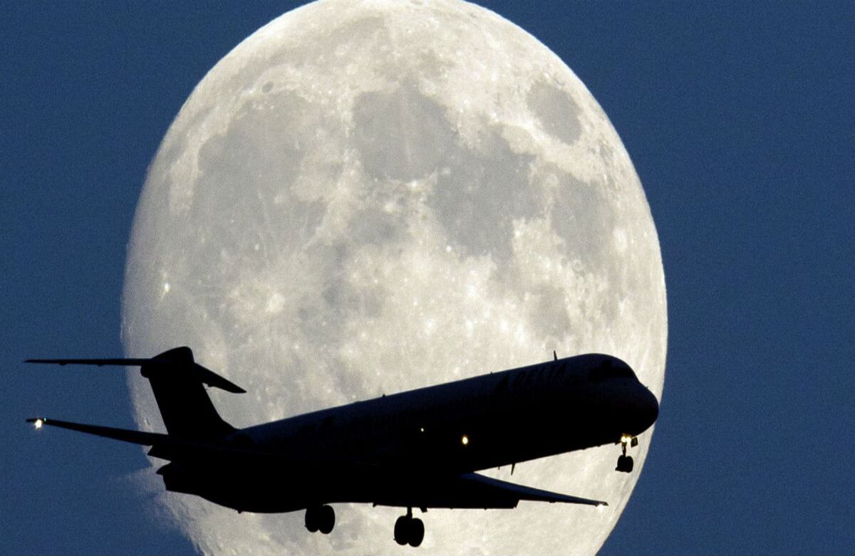 Un avión pasa frente a la luna llena mientras hace su aproximación al Aeropuerto Internacional de Filadelfia, Estados Unidos. (AP) 