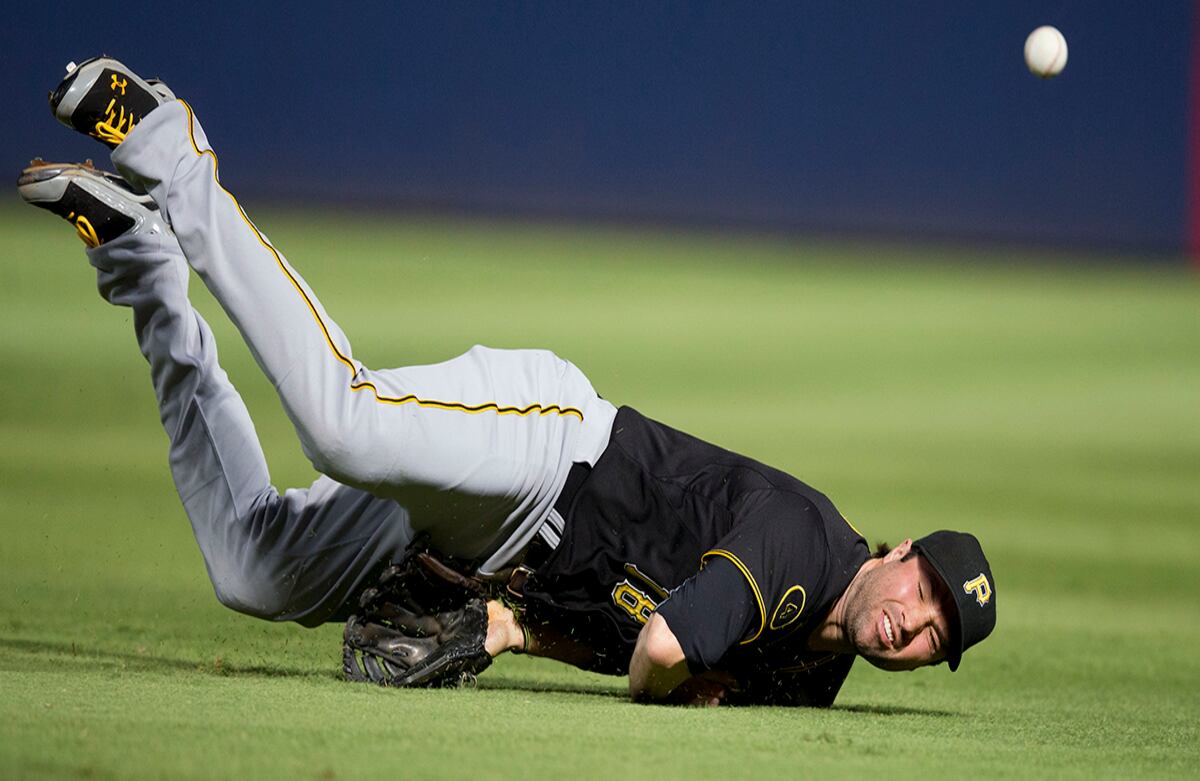 A pesar de un monumental intento por atraparla, una pelota bateada por Christian Bethancourt de los Atlanta Braves’ queda por fuera del alcance de Neil Walker, de los Pittsburgh Pirates. (AP)