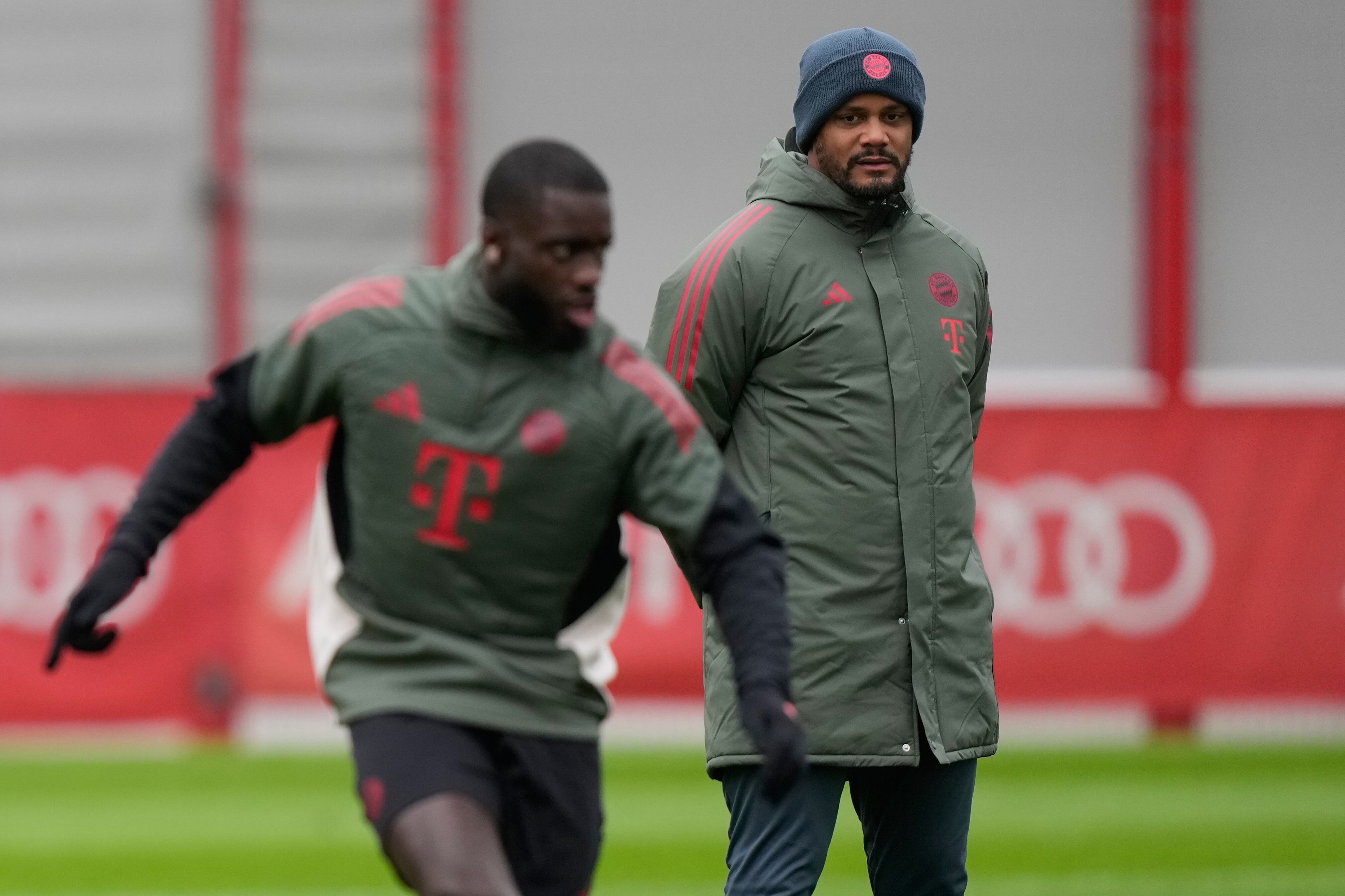 Bayern's Dayot Upamecano kicks a ball in front of head coach Vincent Kompany during a training session in Munich, Germany, Tuesday, Nov. 25, 2025, ahead of the Champions League opening phase soccer match between Arsenal London and FC Bayern. (AP Photo/Matthias Schrader)
