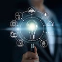 Hombre que sostiene la lupa y la bombilla, la búsqueda del consumo mundial muestra el consumo mundial con fuentes de energía de iconos para el desarrollo sostenible y renovable. Concepto de ecología