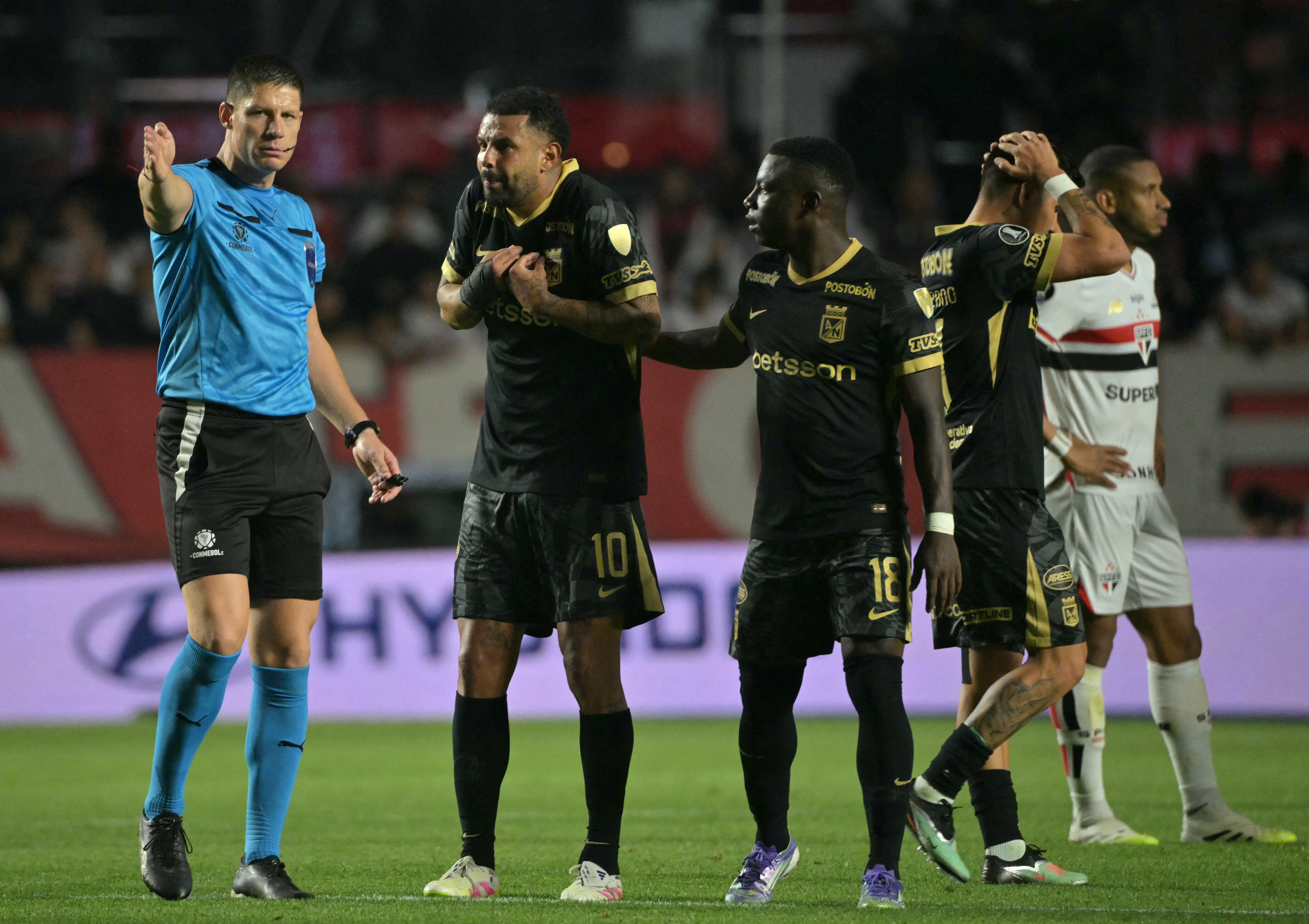 El árbitro argentino Maximiliano Ramírez hace un gesto después de mostrar una tarjeta roja al mediocampista del Atlético Nacional #10 Edwin Cardona durante el partido de vuelta de los octavos de final de la Copa Libertadores entre el Sao Paulo de Brasil y el Atlético Nacional de Colombia en el Estadio Morumbi en Sao Paulo, Brasil, el 19 de agosto de 2025. (Foto de NELSON ALMEIDA / AFP)