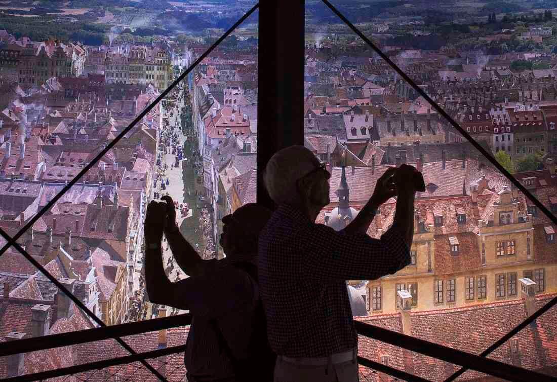 Los visitantes hacen fotos delante de la monumental imagen panorámica "Dresde barroco - Mito de la ciudad real de Sajonia" del artista Yadegar Asisi en el Dresden asisi Panometer en Dresden, Alemania oriental, jueves 22 de junio de 2017. (AP Photo / Jens Meyer)