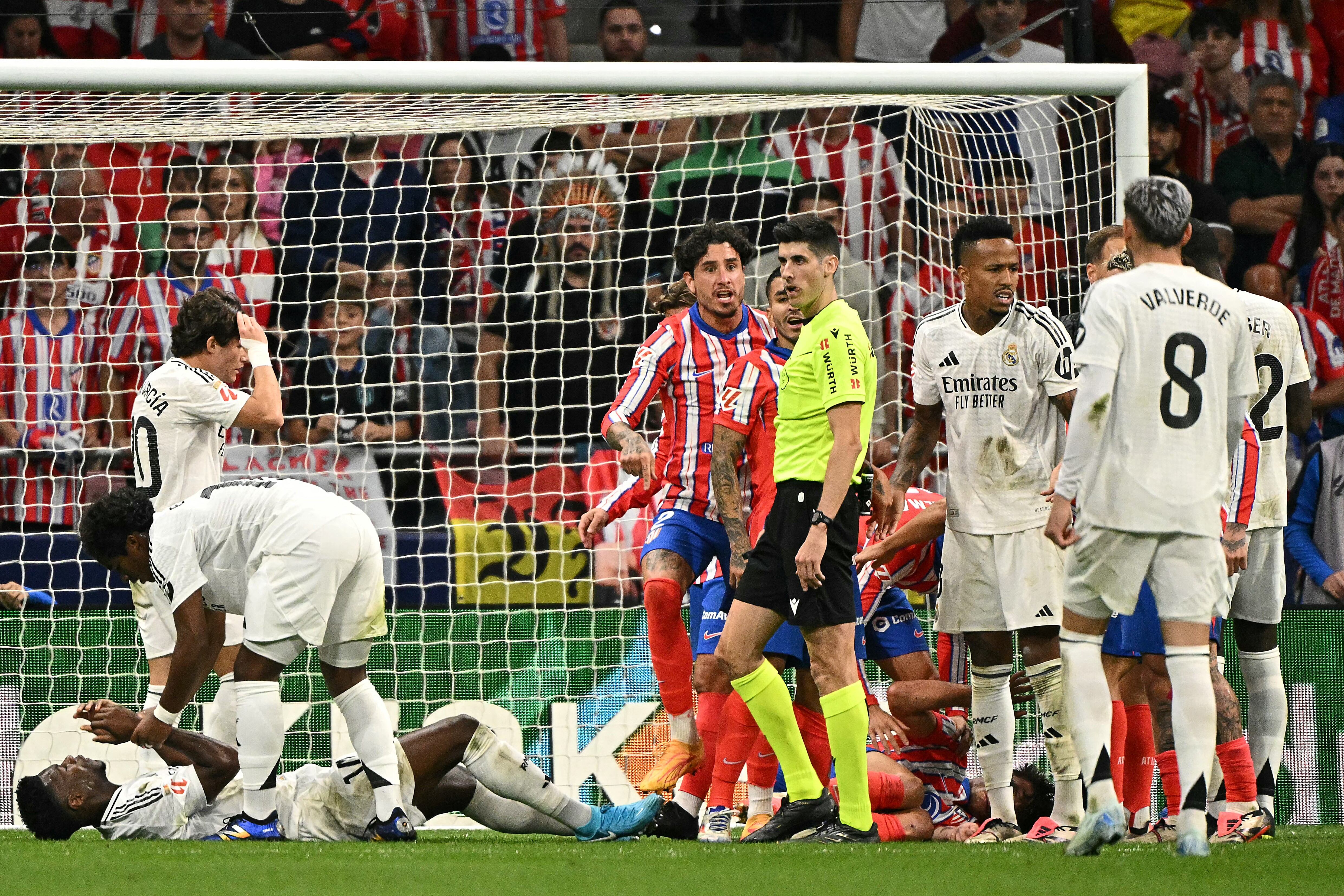 Real Madrid's French midfielder #14 Aurelien Tchouameni and Atletico Madrid's Spanish defender #24 Robin Le Normand lie on the ground during the Spanish league football match between Club Atletico de Madrid and Real Madrid CF at the Metropolitano stadium in Madrid on September 29, 2024. (Photo by JAVIER SORIANO / AFP)