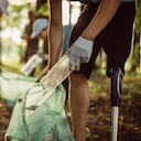 Group of multi-ethnic people, people with differing abilities , volunteers with garbage bags cleaning park area