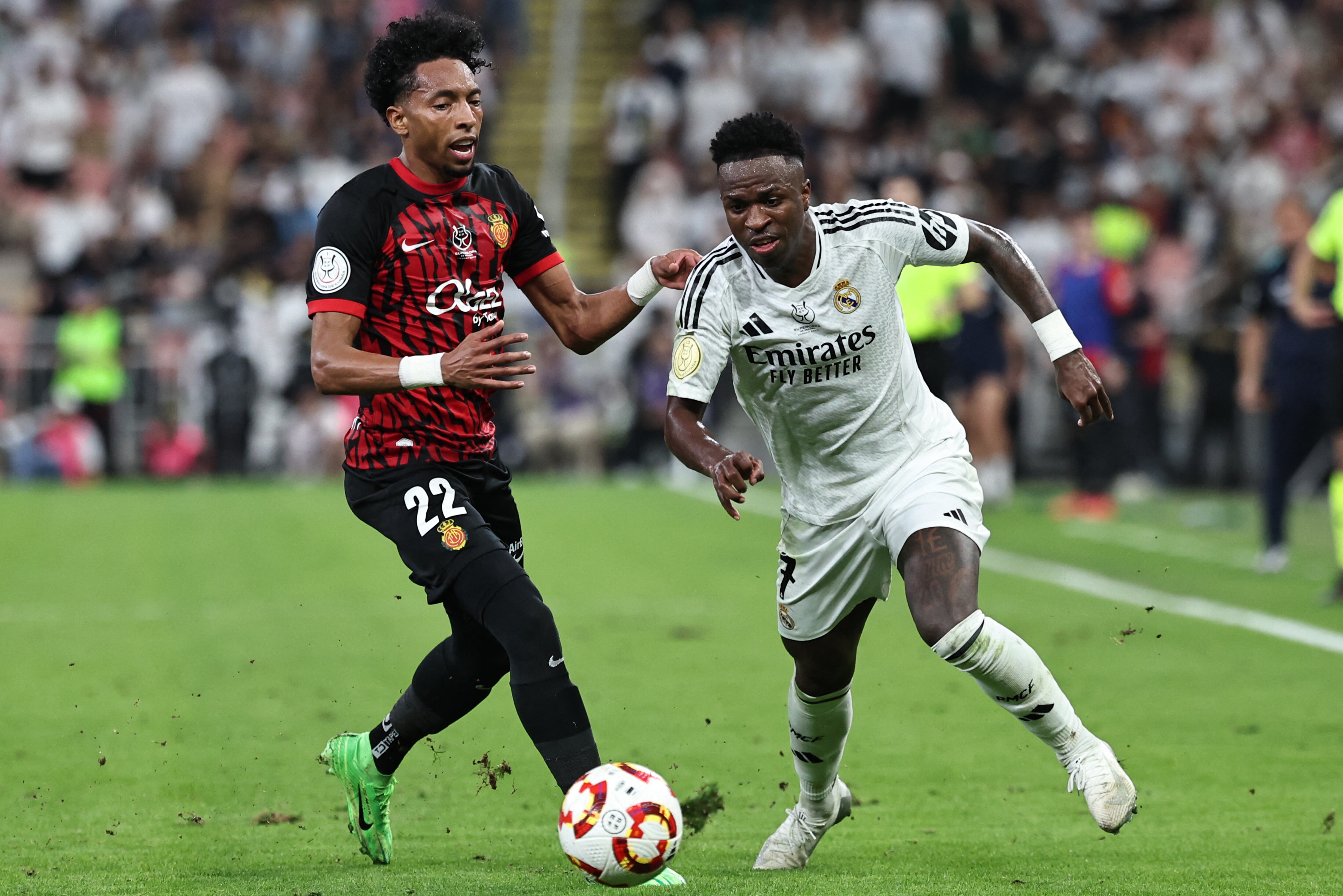 El defensa colombiano del Real Mallorca #22 Johan Mojica lucha por el balón con el delantero brasileño del Real Madrid #7 Vinicius Junior durante el partido de fútbol de semifinales de la Supercopa de España entre el Real Madrid y el Mallorca en el King Abdullah Sport City de Jeddah el 9 de enero de 2025.