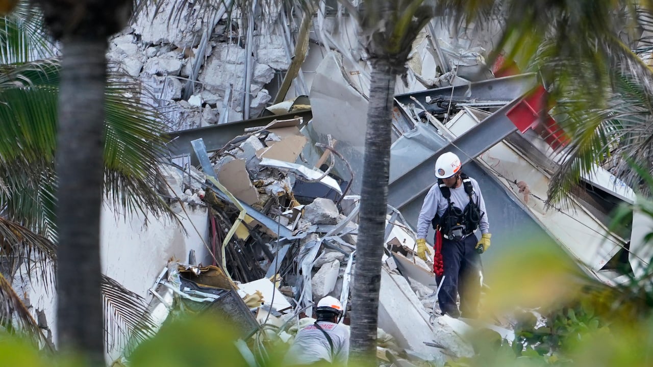 Los rescatistas caminan entre los escombros donde se derrumbó parte de un edificio de condominios frente al mar de 12 pisos, el jueves 24 de junio de 2021, en Surfside, Florida. (AP Photo/Marta Lavandier)
