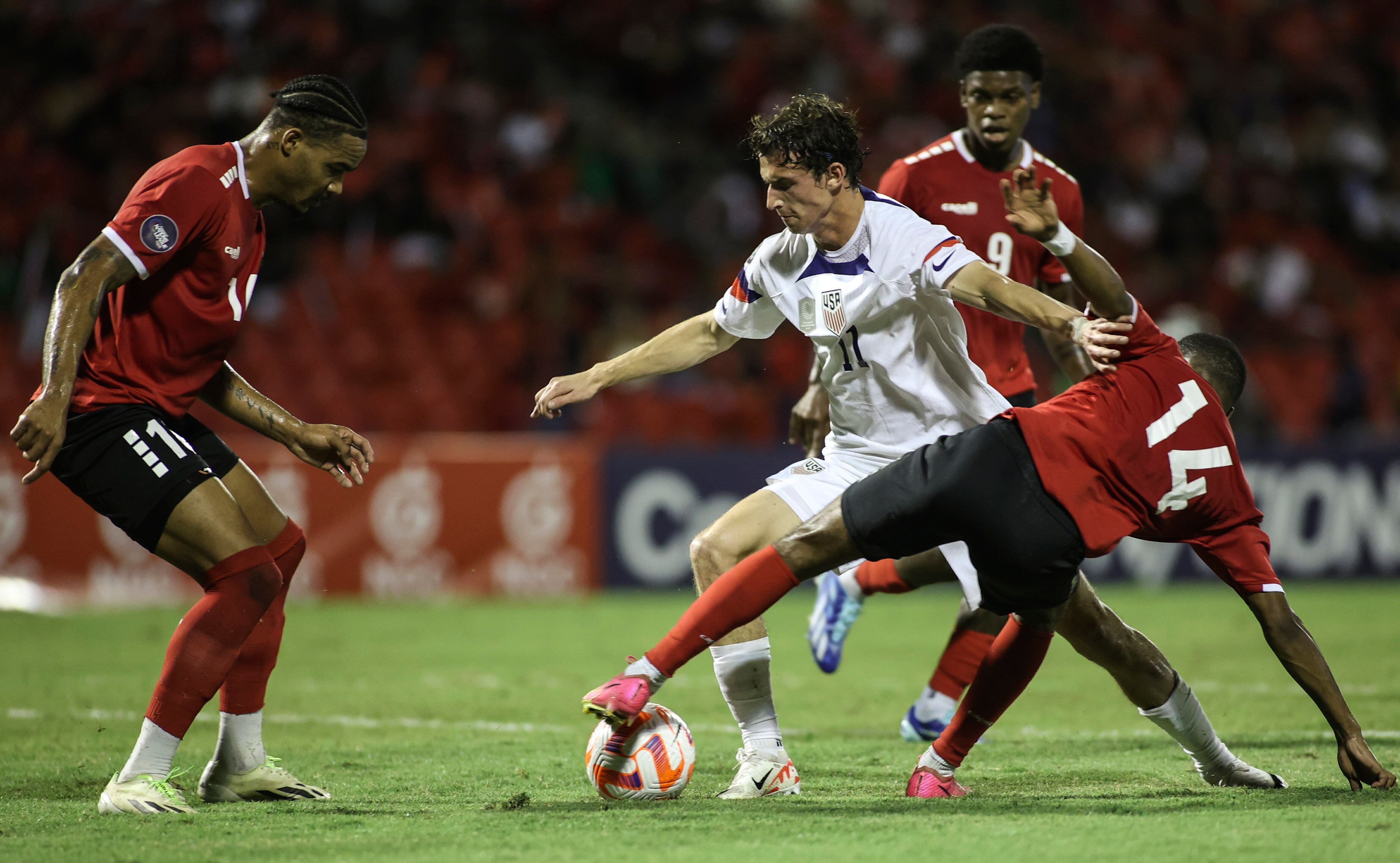 Brenden Aaronson de los Estados Unidos pelea por el balón con Shannon Gomez de Trinidad y Tobago en el encuentro de cuartos de final de la Liga de Naciones CONCACAF el lunes 20 de noviembre del 2023 en Puerto Príncipe, Trinidad y Tobago. (AP Foto/Azlan Mohammed)