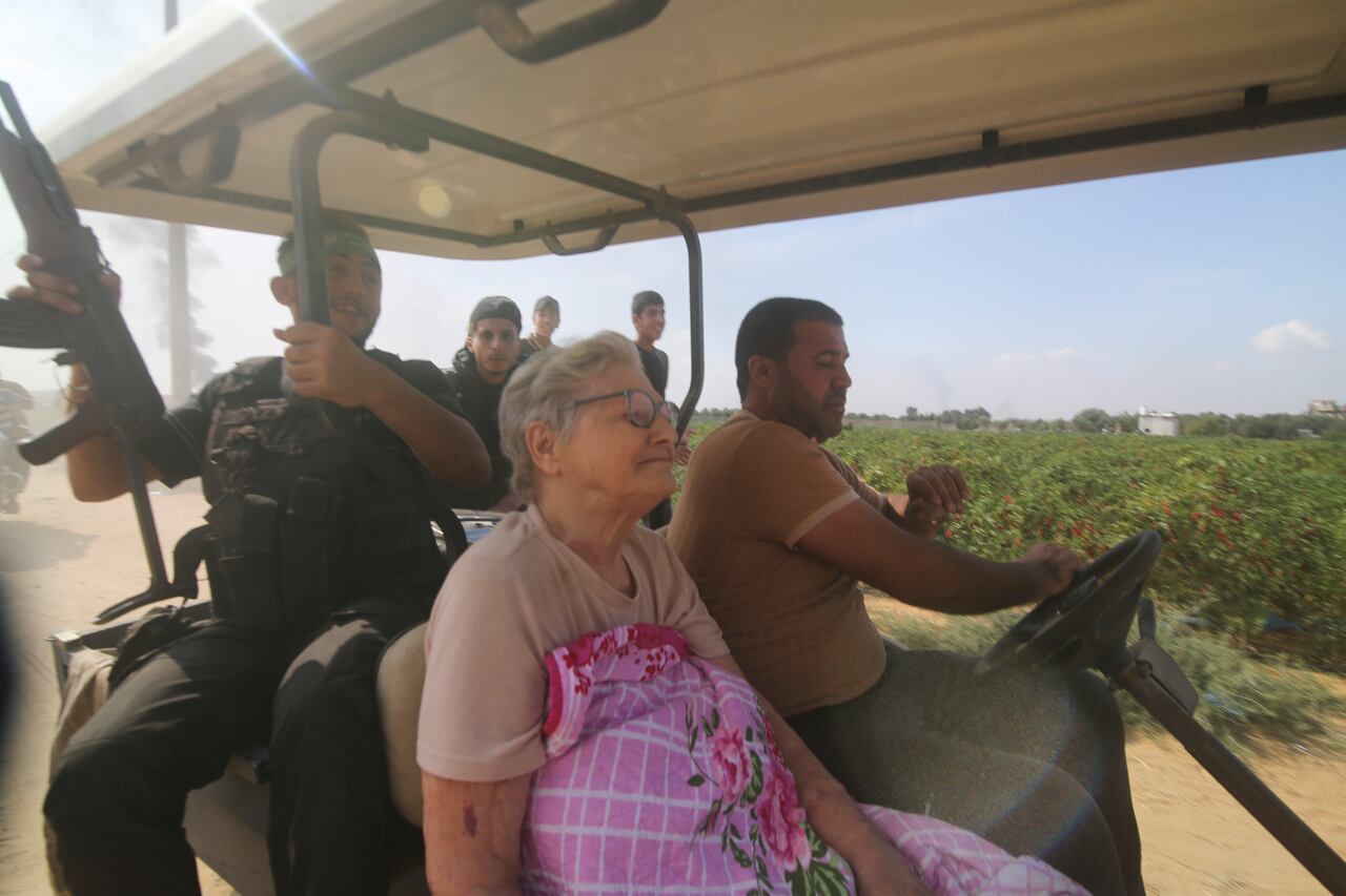 Los palestinos transportan a un civil israelí capturado, en el centro, desde el kibutz Kfar Azza a la Franja de Gaza