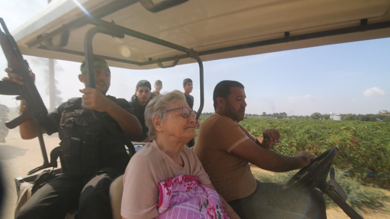 Los palestinos del grupo Hamás transportan a un civil israelí capturado, en el centro, desde el kibutz Kfar Azza a la Franja de Gaza.
