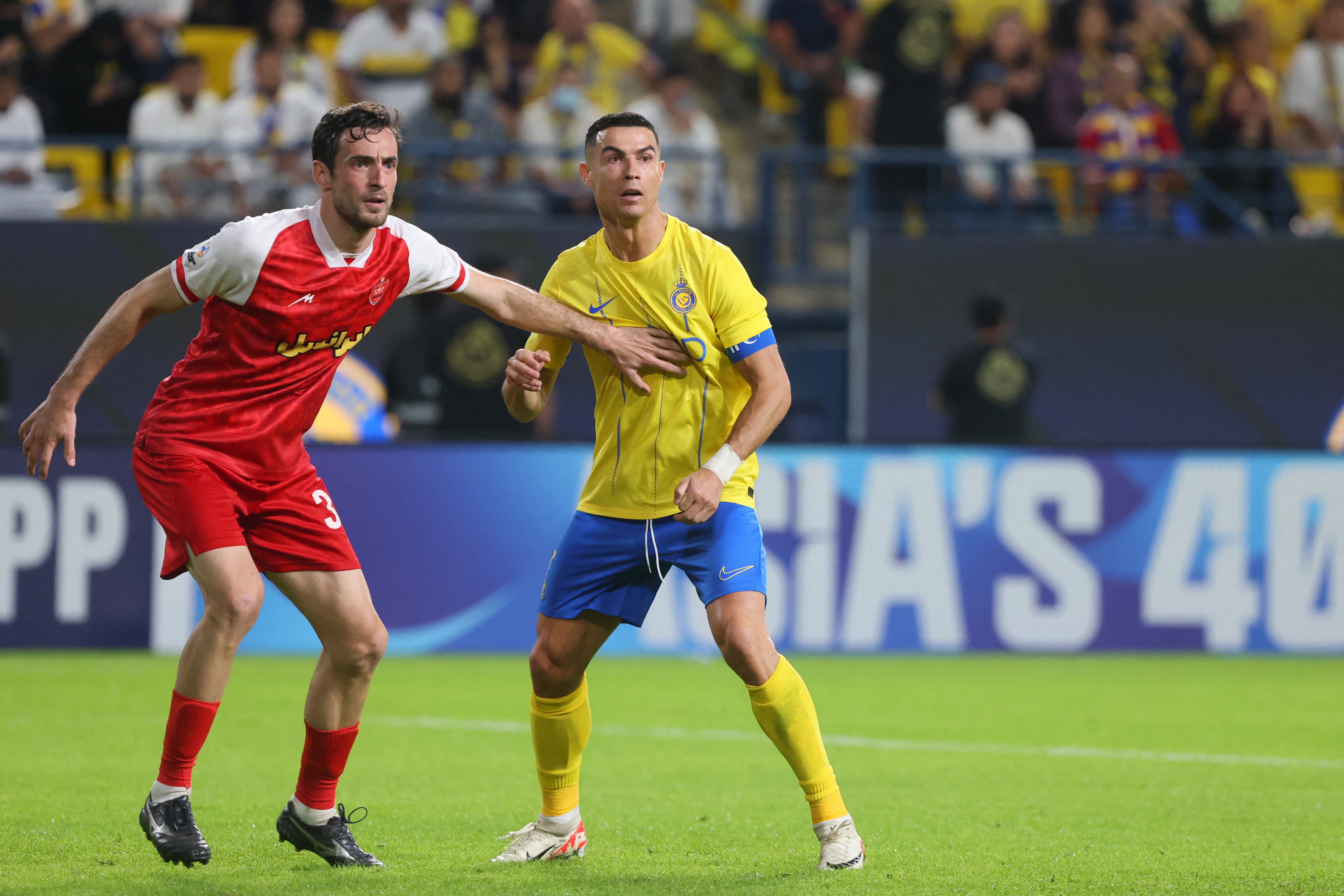 Nassr's Portuguese forward #07 Cristiano Ronaldo is marked by Persepolis' Georgian defender #30 Giorgi Gvelesiani during the AFC Champions League Group E football match between Saudi's al-Nassr and Iran�s Persepolis at the Al-Awwal Stadium in Riyadh on November 27, 2023. (Photo by Fayez NURELDINE / AFP)