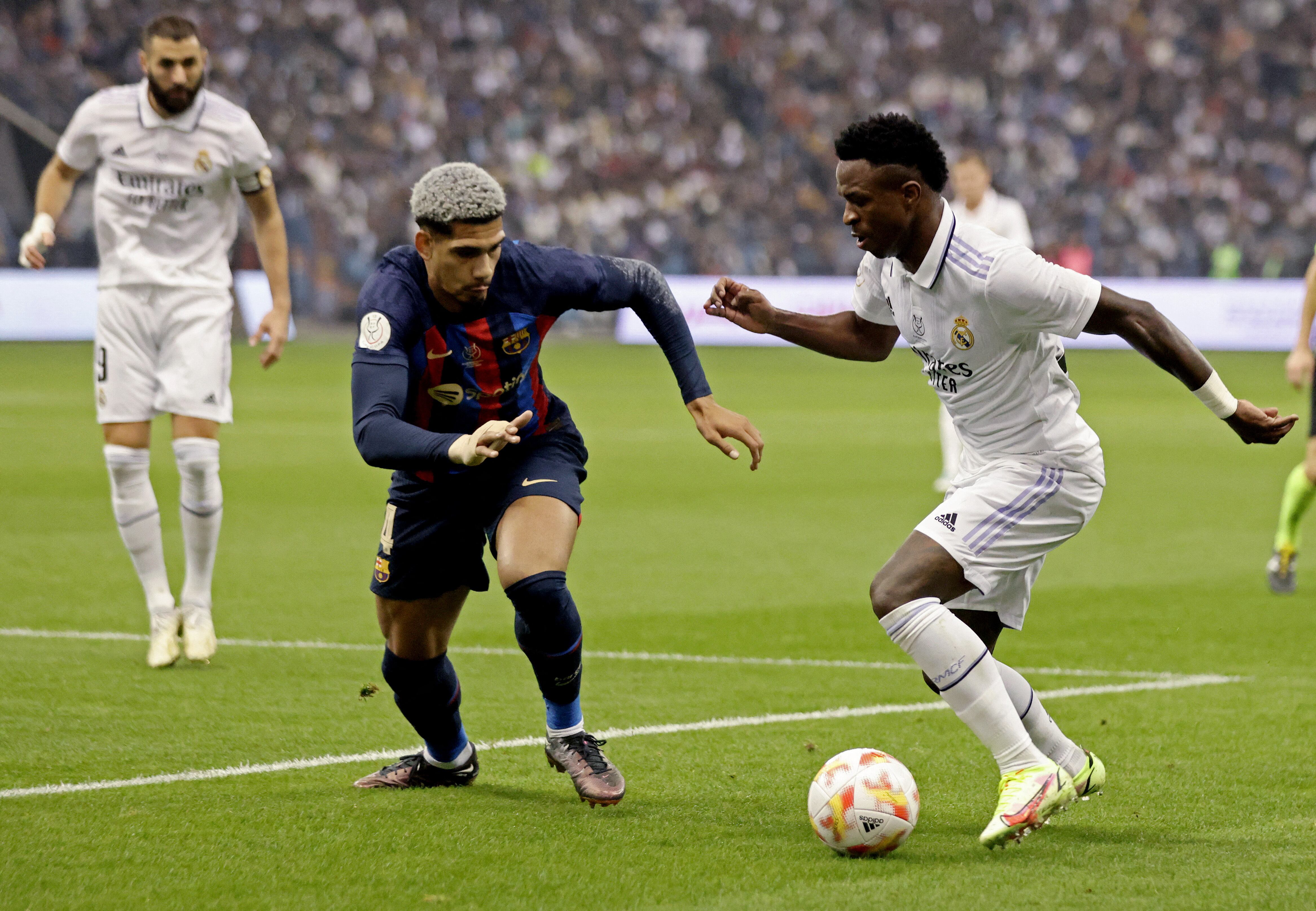 Soccer Football - Spanish Super Cup - Final - Real Madrid v FC Barcelona - King Fahd Stadium, Riyadh, Saudi Arabia - January 15, 2023 FC Barcelona's Ronald Araujo in action with Real Madrid's Vinicius Junior REUTERS/Ahmed Yosri