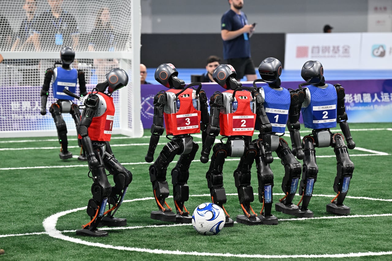 Los robots compiten en un partido de fútbol 3X3 durante los Juegos Mundiales de Robots Humanoides en Beijing el 15 de agosto de 2025. (Foto de ADEK BERRY / AFP)