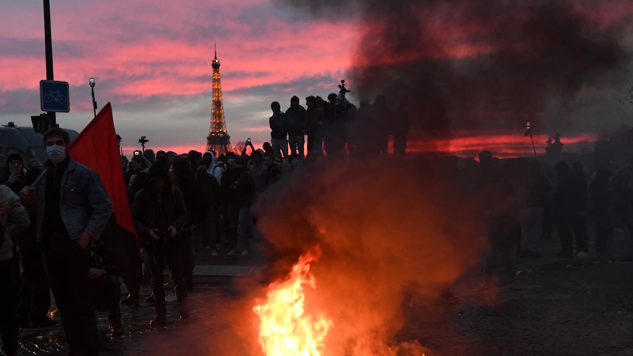 Manifestantes se paran alrededor de las barreras en llamas durante una manifestación en la Place de la Concorde.