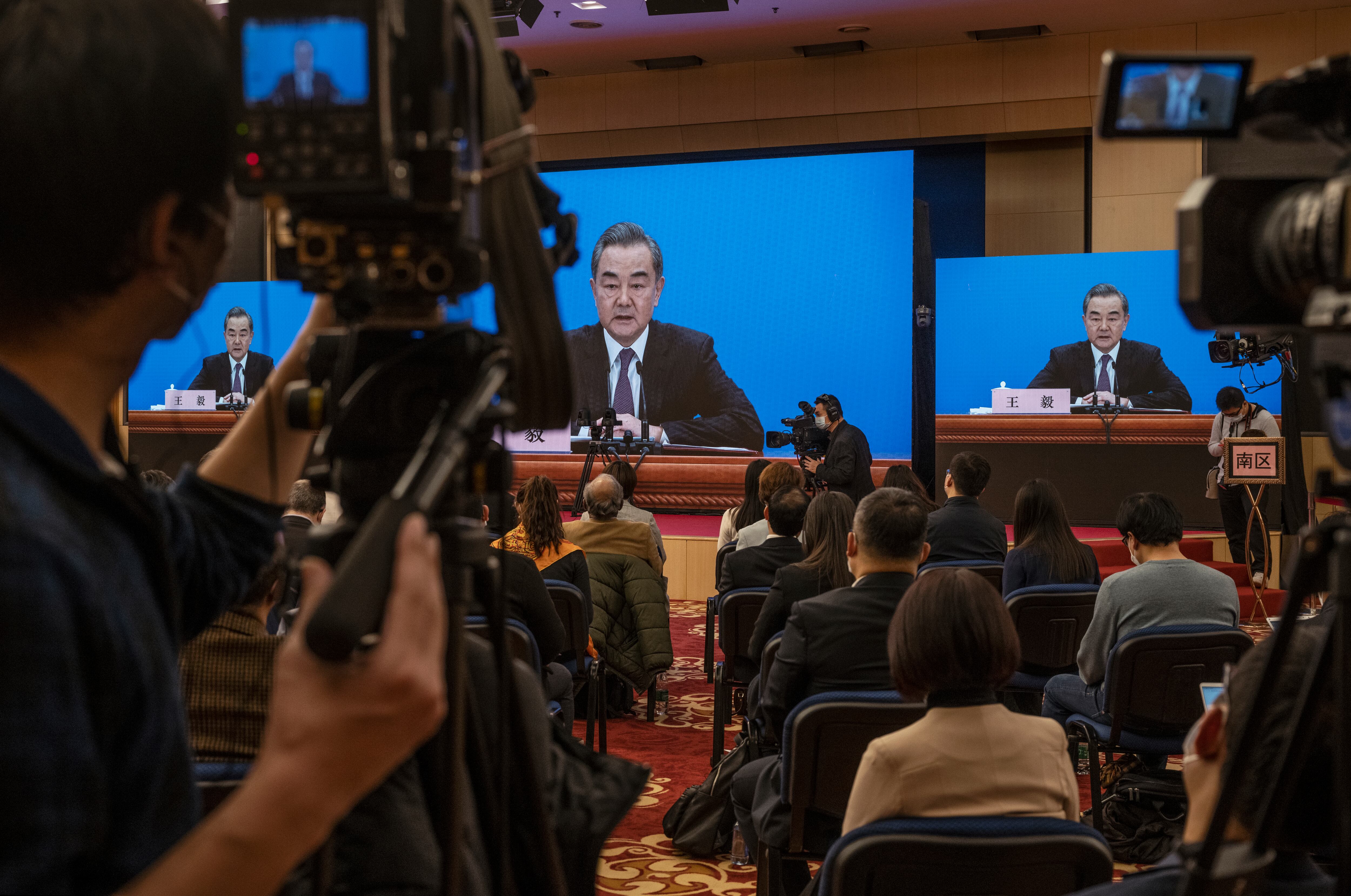 Periodistas chinos y extranjeros ven como el Ministro de Relaciones Exteriores de China, Wang Yi, en la pantalla, responde a una pregunta durante una videoconferencia de prensa, celebrada de forma remota como precaución por el COVID-19, como parte del Congreso Nacional del Pueblo en marzo 7, 2021 en Beijing, China. (Photo by Kevin Frayer/Getty Images)