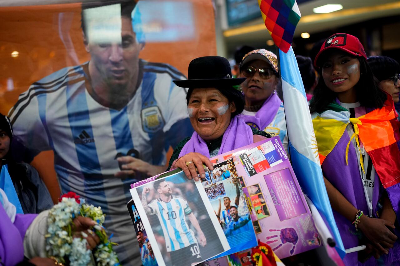 Una mujer sostiene una foto de la estrella del fútbol argentino Lionel Messi mientras espera la llegada de la selección argentina de fútbol al aeropuerto de El Alto, Bolivia, el domingo 10 de septiembre de 2023. (Foto AP/Juan Karita)