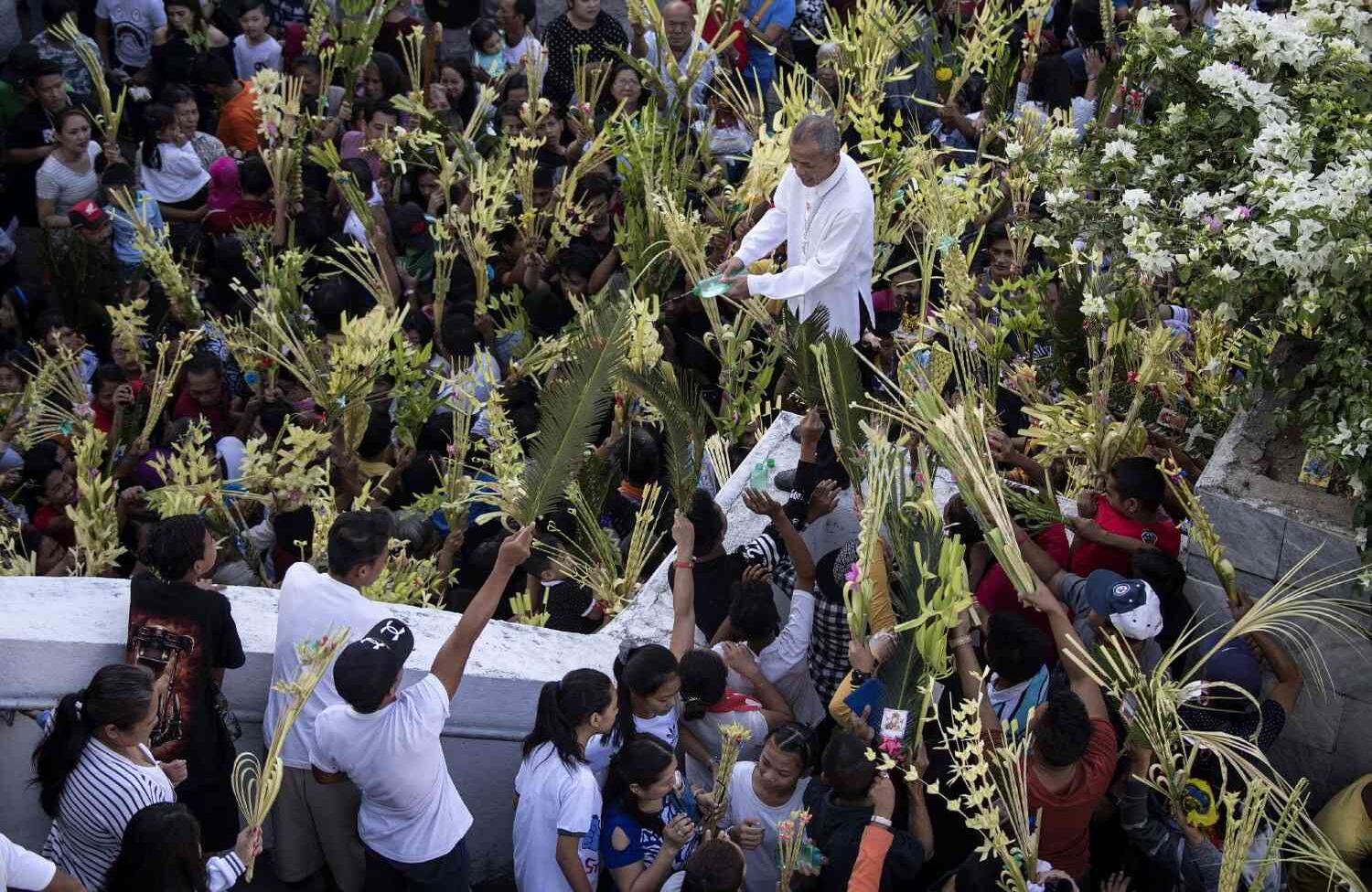 Un seglar de la Iglesia Católica Romana bendice palmas durante las celebraciones del Domingo de Ramos en la iglesia de Nuestra Señora de Lourdes en Bulacan, al norte de Manila el 25 de marzo de 2018. El Domingo de Ramos marca el sexto y último domingo del mes cristiano de la Cuaresma y el comienzo de la Semana Santa. Noel CELIS / AFP