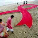 Un joven indio pasa a unos metros de una escultura de arena creada por Sudarshan Pattnaik en el día internacional del SIDA en Puri, India