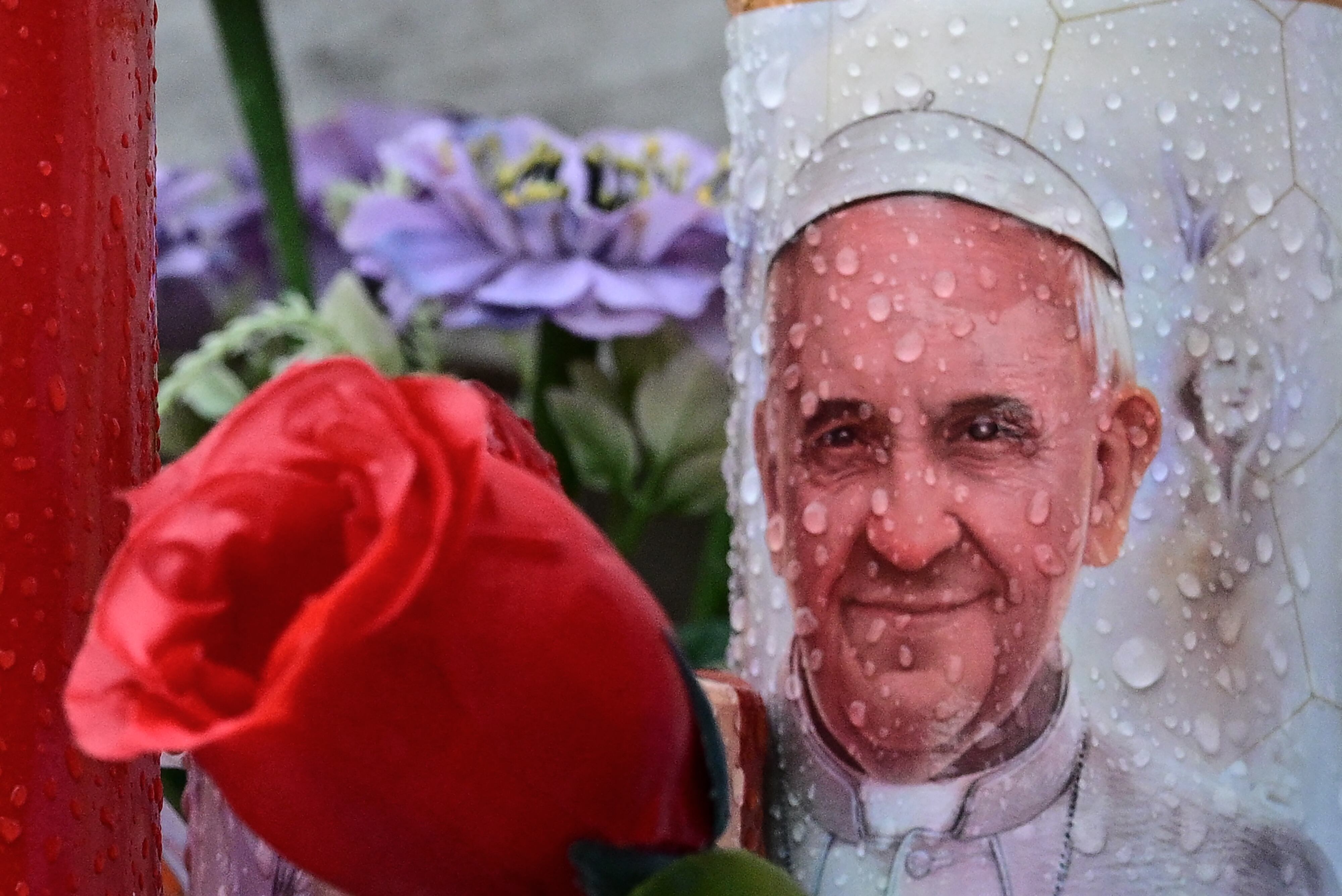 Una vela que representa al Papa Francisco se coloca en la estatua de Juan Pablo II fuera del hospital Gemelli donde el Papa Francisco está hospitalizado en Roma el 25 de febrero de 2025. El Papa Francisco, en estado crítico en el hospital con neumonía, tuvo una buena noche y estaba descansando, dijo el Vaticano el 24 de febrero de 2025. "La noche pasó bien, el Papa durmió y está descansando", dijo en un breve comunicado cuando Francisco, de 88 años, entró en su undécimo día en el Hospital Gemelli de Roma, lo que la convierte en la hospitalización más larga de su papado. (Foto de Tiziana FABI / AFP)
