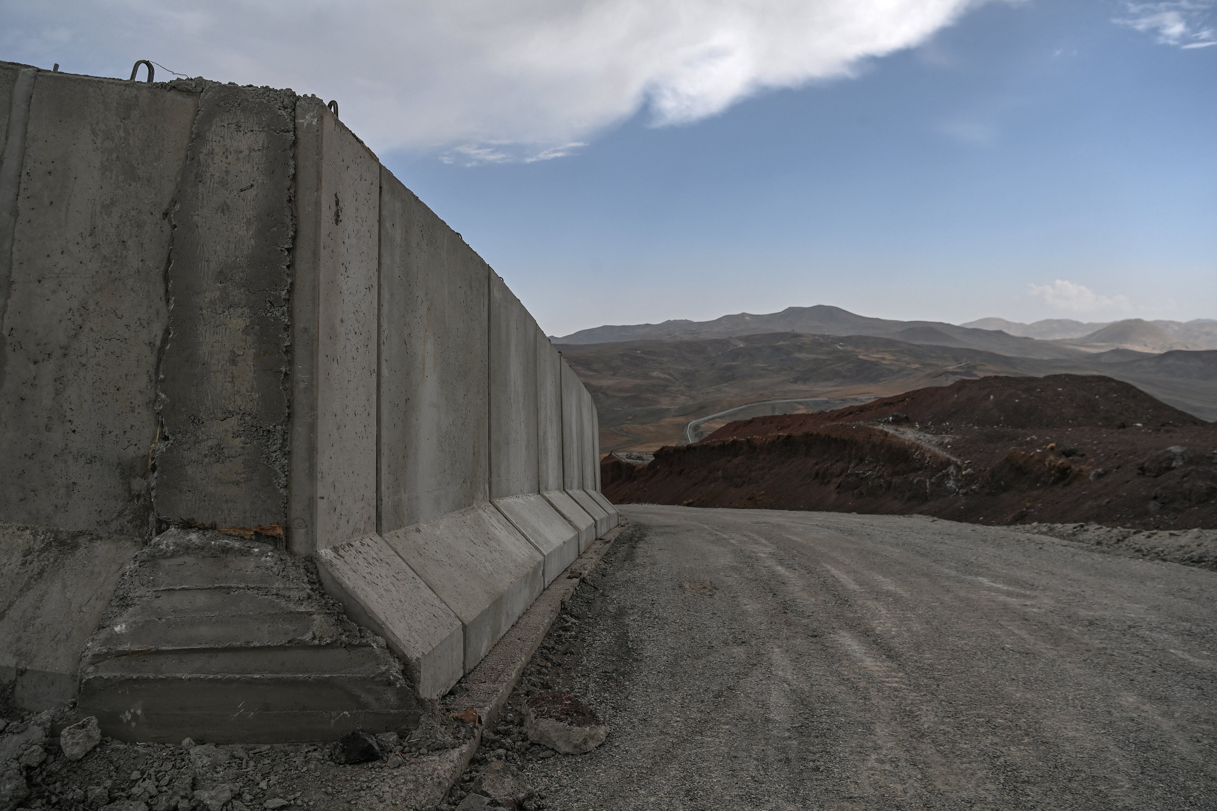 A picture taken on August 16, 2021 shows Turkey�s newly completed border wall in Caldiran, eastern Turkey, in the buffer zone at the frontier with Iran. - The latest chaos in Afghanistan sparked by the recent gains of territory by the Taliban including the takeover of the capital Kabul has raised fresh alarm over an influx of migrants into Turkey through the Iranian border. Turkey, which shares a 534 kilometre (331 miles) border with Iran, has beefed up its frontier and started building a 243 kilometre wall in a bid to prevent any passage of illegal migrants.� (Photo by Ozan KOSE / AFP)