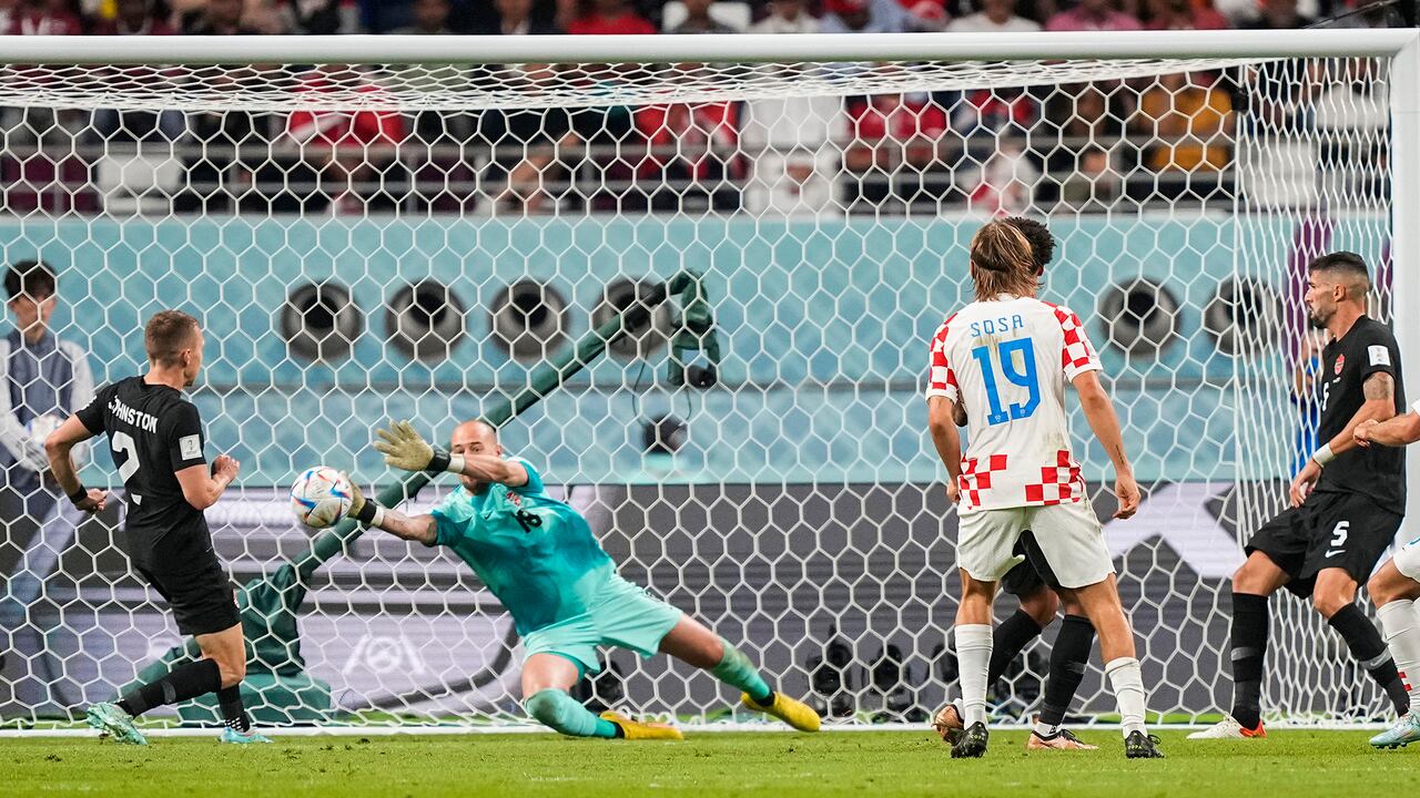 El portero de Canadá Milan Borjan, centro, defiende un tiro durante el partido de fútbol del grupo F de la Copa Mundial entre Croacia y Canadá, en el Estadio Internacional Khalifa en Doha, Qatar, el domingo 27 de noviembre de 2022.