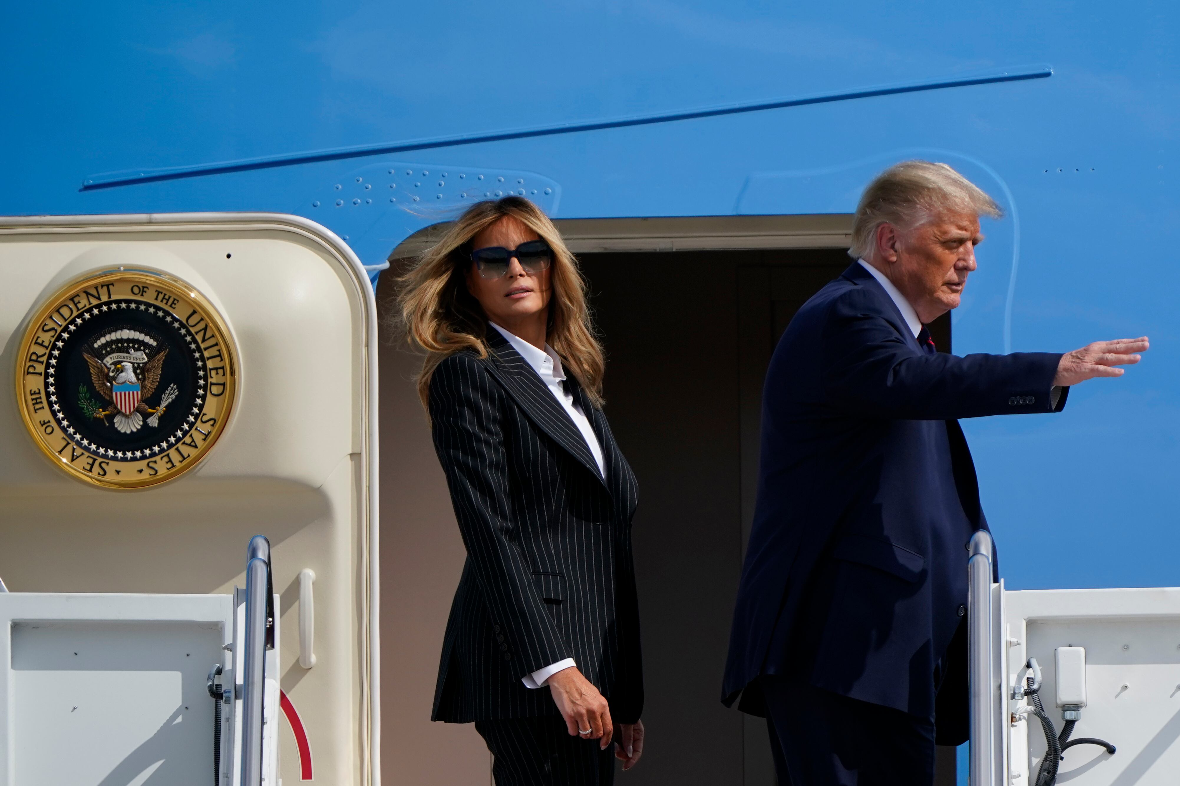 El presidente, Donald Trump, y la primera dama, Melania Trump, caminan para abordar el avión Air Force One que los llevó a Cleveland, Ohio.