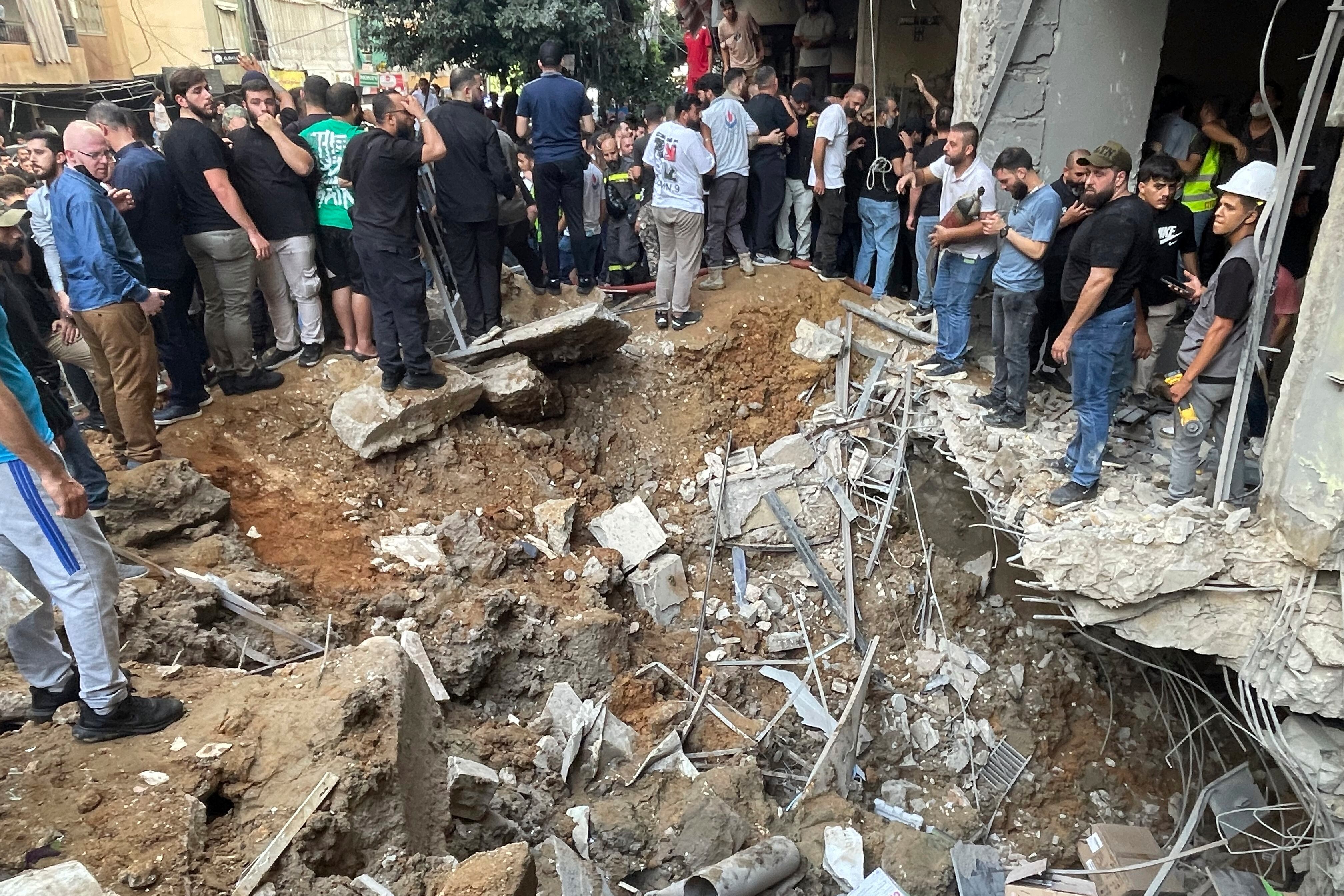 La gente se reúne en el lugar de un ataque con misiles israelí en los suburbios del sur de Beirut, el viernes 20 de septiembre de 2024. (Foto AP/Bilal Hussein)