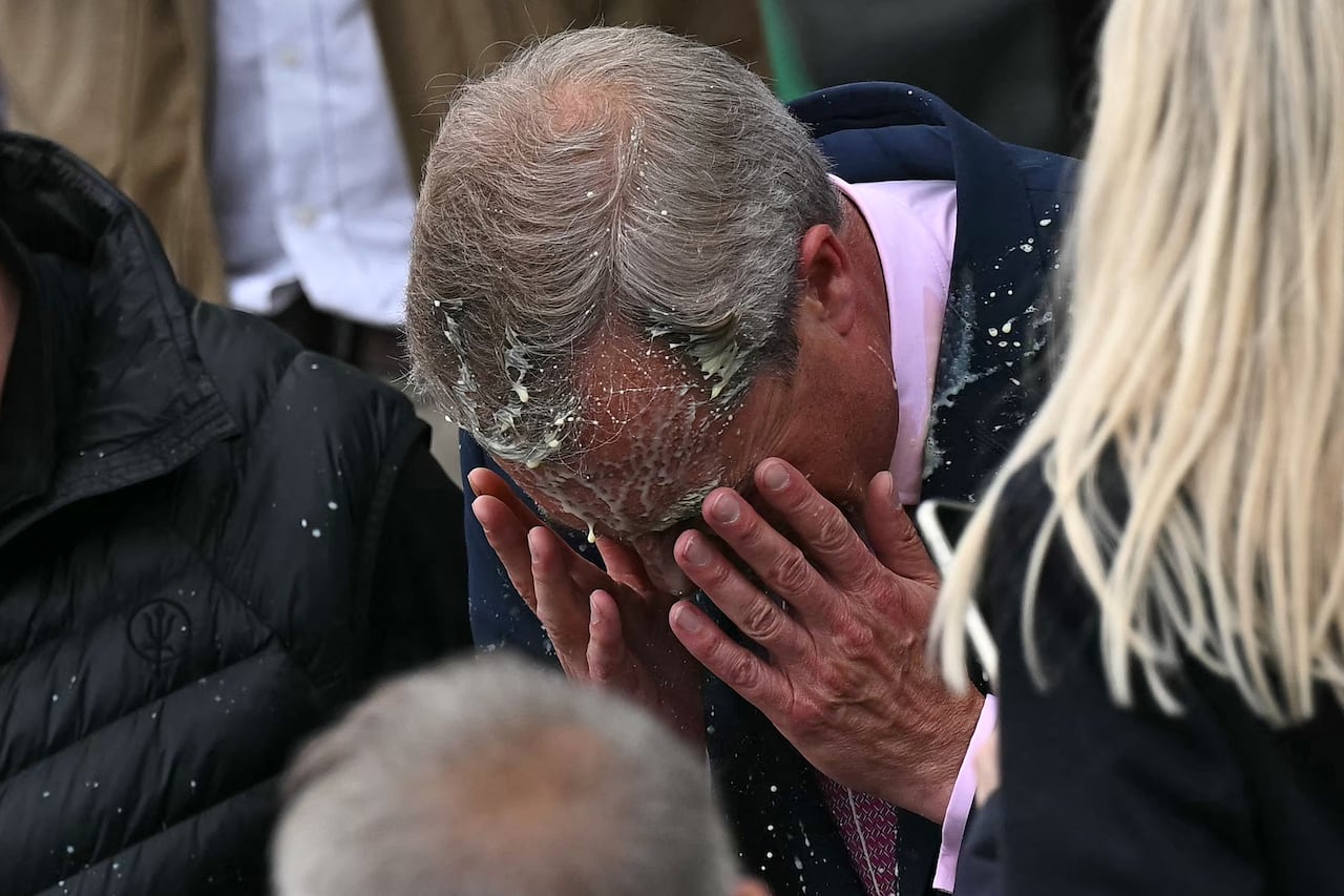 Nigel Farage, recién nombrado líder del partido populista de derecha británico, Reform UK, y candidato parlamentario del partido por Clacton, reacciona después de ser golpeado en la cara por el contenido de un vaso, durante el lanzamiento de su campaña electoral general en Clacton-on- Sea, este de Inglaterra, el 4 de junio de 2024.